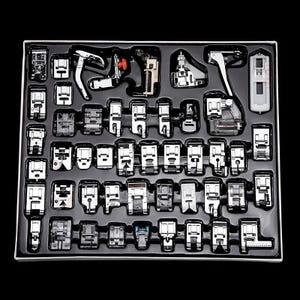 May include: A set of sewing machine presser feet in a black tray. The feet are made of silver metal and come in various shapes and sizes. The tray is rectangular and has a white border.