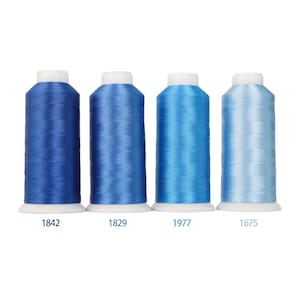 Peut inclure: Quatre bobines de fil à broder disposées en rangée, présentant un dégradé de nuances de bleu, du plus foncé au plus clair. Chaque bobine possède une base et un sommet blancs, avec les numéros 1842, 1829, 1977 et 1675 inscrits en bleu sous chaque bobine.