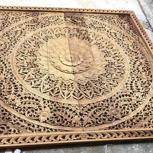 Puede incluir: Panel de madera tallada, grande y cuadrado, con intrincados detalles. Presenta un dise&ntilde;o floral central rodeado de patrones detallados y un borde decorativo. La madera tiene un tono c&aacute;lido y natural, mostrando la artesan&iacute;a. Adecuado para decoraci&oacute;n mural.