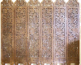 May include: A six-panel room divider made of intricately carved wood with a floral design. The divider is brown and has a traditional Asian style.