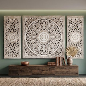 Può includere: Un set di tre pannelli da parete in legno, rettangolari e quadrati, caratterizzati da intricati motivi floreali e geometrici intagliati a mano con una finitura bianca anticata. Il pannello centrale quadrato presenta un grande mandala.