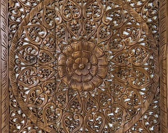 Könnte beinhalten: Eine große, kunstvoll geschnitzte Holz-Wandverkleidung mit einem runden Design, das eine zentrale Blume und umgebende florale Motive zeigt. Die Verkleidung ist aus dunkelbraunem Holz gefertigt und hat einen rustikalen, antiken Look.