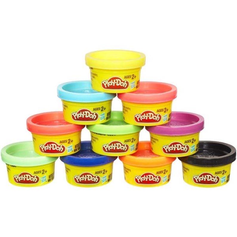 May include: A collection of Play-Doh containers in various colors, including yellow, blue, red, green, purple, orange, and black. Each container has a yellow lid and the Play-Doh logo. The text "AGES 2+" is visible on each container.