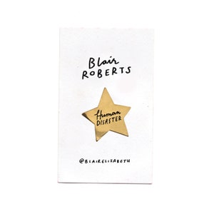 Human Disaster, gold star enamel pin image 1