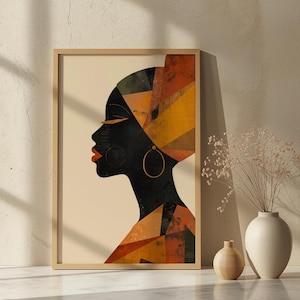 Peut inclure: Impression d'art encadrée représentant le profil d'une femme à la peau foncée, coiffée d'un turban aux motifs géométriques orange, jaune et vert. Elle porte des créoles dorées et du rouge à lèvres rouge. L'œuvre est dans un cadre en bois.