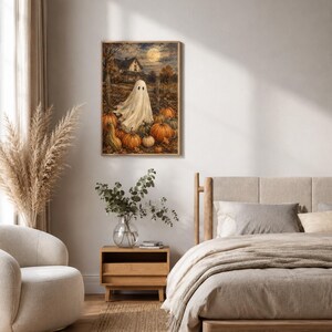 May include: A rectangular wall art print featuring a white ghost standing in a pumpkin patch at night. The scene includes a full moon, a dark house in the background, and numerous orange pumpkins scattered across the ground in a rustic setting.
