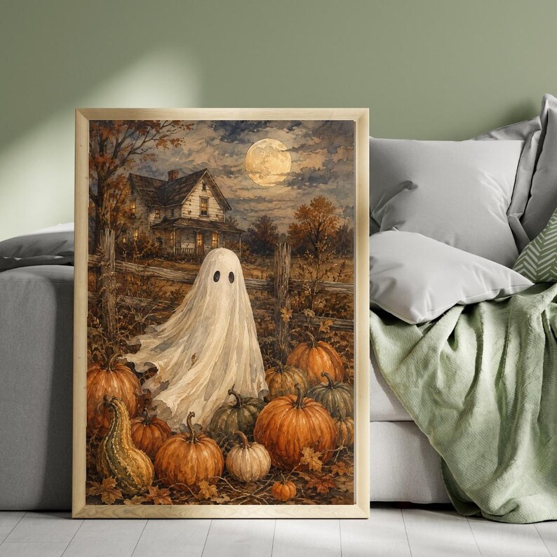 May include: A framed wall art print depicting a white ghost standing in a pumpkin patch at night. In the background, a two-story house sits under a full moon. The scene features orange pumpkins, autumn foliage, and a wooden fence in a dark, moody style.