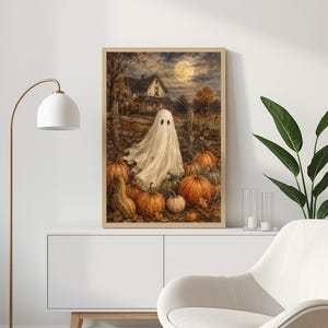 May include: A rectangular wall art print featuring a white ghost standing in a pumpkin patch at night. In the background, a house sits under a full moon and a cloudy sky. The scene includes numerous orange pumpkins and a gourd on the ground.