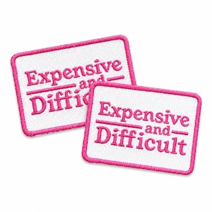 Puede incluir: Dos parches rectangulares bordados con fondo de tela blanca y bordes cosidos en rosa brillante. Cada parche presenta el texto "Expensive and Difficult" en bordado rosa, con la palabra "and" situada entre dos líneas horizontales.