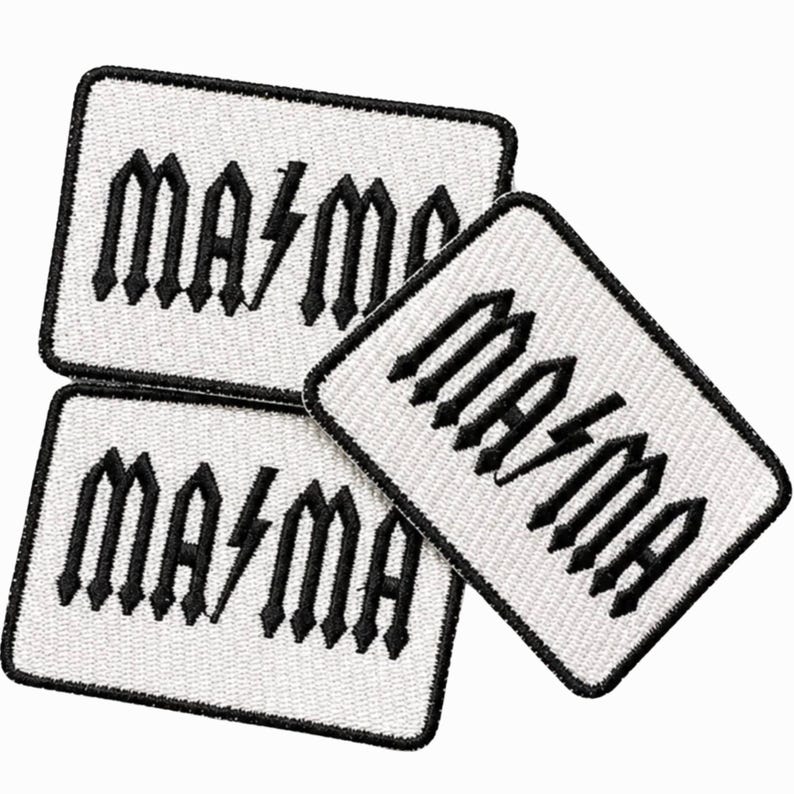 May include: Three rectangular embroidered patches with white backgrounds and black borders. Each patch features the black text "MA⚡MA" in a stylized, angular font, with a lightning bolt symbol replacing the letter "M" in the center.