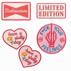 May include: A collection of five embroidered patches including a rectangular patch with the text Babewciser, a rectangular patch with the text LIMITED EDITION, two heart-shaped patches with the text have a slutty day and a flower, and a circular patch with a skeleton hand and the text F*CK YOUR FEELINGS.