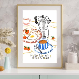 May include: A framed print featuring a breakfast scene with a coffee maker, a blue and white striped coffee cup, toast, and fried eggs. The print includes the text "Hello Morning coffee & toast" in a whimsical font. The frame is gold.