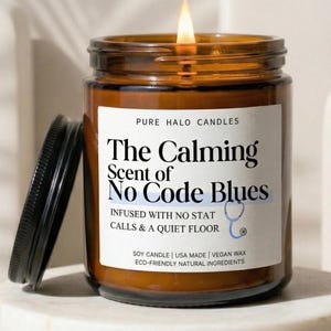 May include: A set of three ceramic mugs with a speckled, cream-colored glaze. Each mug features a different hand-painted design: a blue and green leaf, a yellow flower, and a red berry. The mugs have a simple, rounded shape.