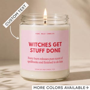 May include: A lit 9oz vegan soy wax candle in a clear glass jar with a pink label. The label reads PURE HALO CANDLES, WITCHES GET STUFF DONE, Every burn releases pure scent of spellbooks and finished to do lists, and VEGAN SOY WAX CANDLE | 9OZ.