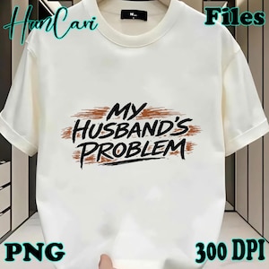May include: A white t-shirt with the phrase "MY HUSBAND'S PROBLEM" in black lettering with a brown brushstroke design. The shirt has short sleeves and a crew neck. The image also includes the text "PNG" and "300 DPI".