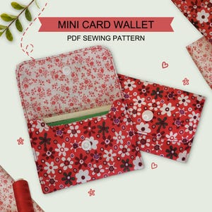May include: Two mini card wallets featuring a red fabric with a white and dark floral pattern. One wallet is open, showing the interior lining, while the other is closed with a white snap button. Text reads MINI CARD WALLET PDF SEWING PATTERN.