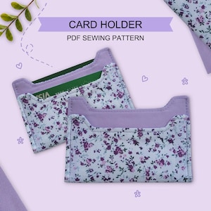 Puede incluir: Dos tarjeteros rectangulares de tela blanca con un pequeño estampado floral morado y un borde liso de color lavanda. El texto CARD HOLDER PDF SEWING PATTERN aparece en la parte superior. Uno contiene una tarjeta verde con texto visible.
