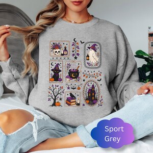 May include: A sport grey crewneck sweatshirt featuring a graphic print of various Halloween-themed illustrations arranged in rectangular frames, including a skull, a ghost, a black cat, a cauldron, a haunted house, and a raven on books.