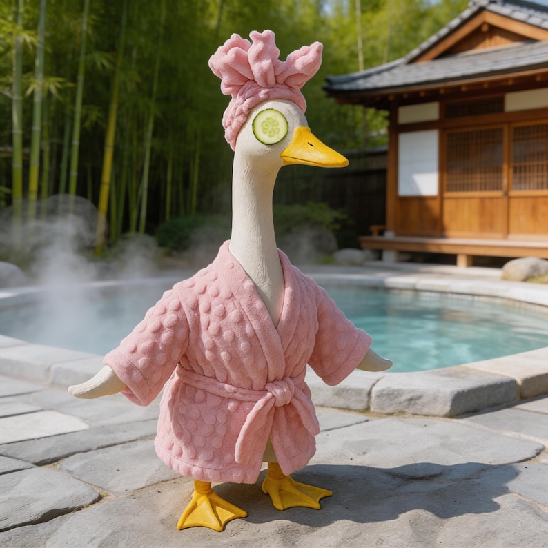 May include: A whimsical sculpture of a goose in a spa setting. The goose wears a pink robe, a matching head wrap, and has cucumber slices over its eyes. The background includes a pool, bamboo, and a traditional Japanese building.
