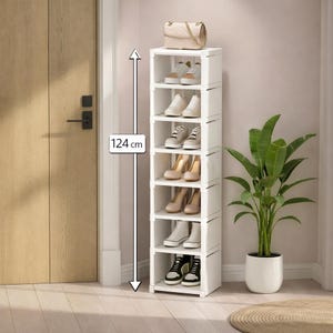 Pode incluir: Um sapateira branca de 124 cm de altura com seis prateleiras, contendo vários sapatos e uma bolsa. A sapateira está ao lado de uma planta de interior num vaso branco. A porta e a parede são claras.