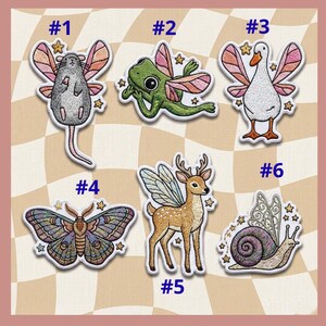 May include: Embroidered patches featuring whimsical creatures with fairy wings, including a mouse, frog, goose, moth, deer, and snail. Each patch is surrounded by small star accents and numbered for easy selection.