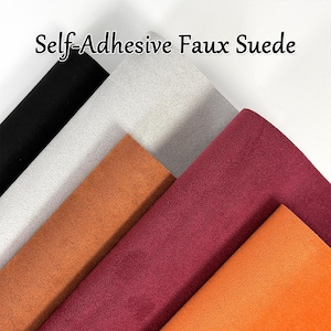 Può includere: Una collezione di tessuto scamosciato sintetico autoadesivo in vari colori, tra cui nero, grigio, arancione e bordeaux. Il tessuto è disposto a strati sovrapposti, mostrando la trama e le variazioni di colore. Il testo "Self-Adhesive Faux Suede" è visualizzato in alto.