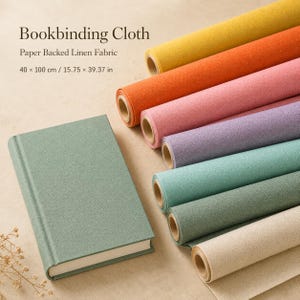 Peut inclure: Rouleaux de tissu de reliure en lin contrecollé sur papier en jaune, orange, rose, violet, bleu sarcelle, vert et beige, avec un livre vert sauge. Le texte indique : Bookbinding Cloth, Paper Backed Linen Fabric, 40 x 100 cm / 15.75 x 39.37 in.