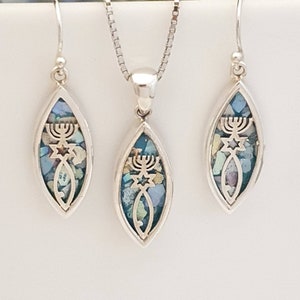 May include: A silver necklace and earrings set with a pendant and earrings featuring a menorah, Star of David, and a fish design. The pendant and earrings are made of silver and are inlaid with colorful mosaic tiles.