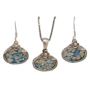 May include: A silver necklace and earrings set with a floral design and a blue and white mosaic pendant.