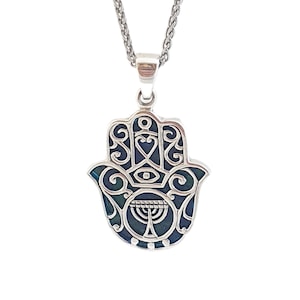 Puede incluir: Collar con colgante de mano de Hamsa de plata de ley con incrustaciones de esmalte azul y verde y un diseño de menorá.