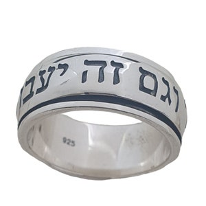 May include: A silver ring with a black band and Hebrew writing around the band. The writing says "Atah Kedoshe" which means "You are Holy".