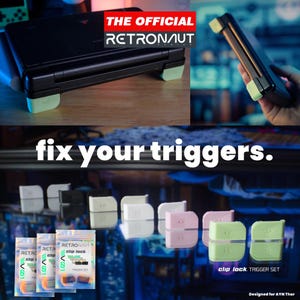 Könnte beinhalten: Schwarze Handheld-Spielkonsole mit mintgrünen Akzenten und dem Text "THE OFFICIAL RETRONAUT". Das Bild zeigt auch "fix your triggers." und "clip lock TRIGGER SET" mit verschiedenen farbigen Trigger-Sets.