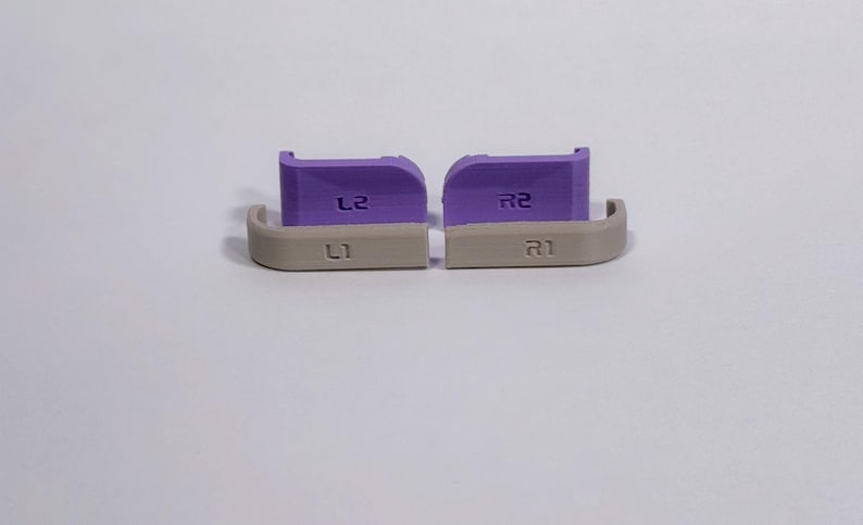 Puede incluir: Un juego de cuatro botones de hombro de repuesto para mando, compuesto por dos gatillos morados L2 y R2 y dos botones superiores beige L1 y R1. Cada pieza est&aacute; claramente grabada con su etiqueta correspondiente L1, R1, L2 y R2.