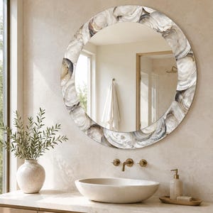 May include: A round wall mirror featuring a decorative frame composed of overlapping oyster shells in shades of white, gray, and brown. The mirror has a smooth, reflective surface and a circular shape, showcasing natural shell textures and patterns.