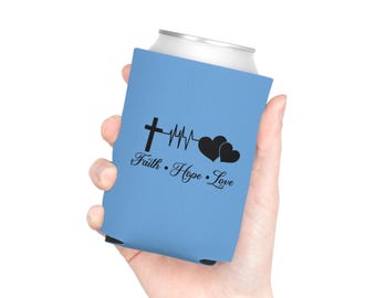 May include: A light blue foam can cooler featuring a black graphic design of a cross, a heartbeat line, and two hearts. Below the graphic, the text Faith • Hope • Love is printed in a black script font on the front of the beverage sleeve.