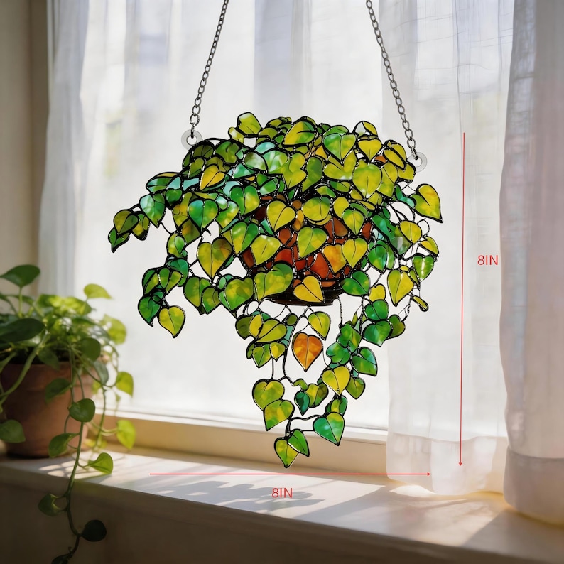 May include: A stained glass hanging plant featuring numerous heart-shaped leaves in shades of green and yellow, suspended by metal chains. The piece measures 20.32 cm in height and 20.32 cm in width, showcasing a vibrant, multi-toned foliage design.