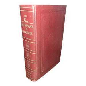May include: A vintage, hardcover book titled "The New Dictionary of Thoughts." The book is bound in a deep red material with gold lettering and decorative accents. The spine features the title and publisher's name.