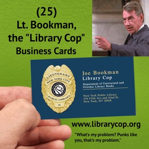 May include: A blue business card with a gold badge featuring a lion and the text "Lieutenant New York City Public Library 35". The card reads "Joe Bookman Library Cop Department of Unreturned and Overdue Library Books New York Public Library 476 Fifth Ave and 42nd St. New York, NY 10018 www.librarycop.org "What's my problem? Punks like you, that's my problem."