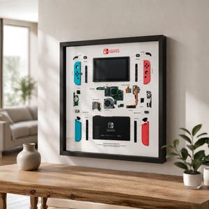 Könnte beinhalten: Ein gerahmtes Wandbild, das eine zerlegte Nintendo Switch-Konsole zeigt. Auf dem weißen Hintergrund sind der Bildschirm, rote und blaue Joy-Con-Controller, interne Platinen, ein Lüfter und die Dockingstation in technischer Anordnung zu sehen.