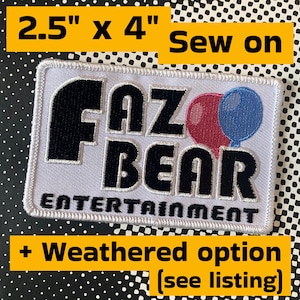 May include: A rectangular sew-on patch measuring 2.5 inches by 4 inches with a white background and a black embroidered border. The patch features the black text FAZ BEAR ENTERTAINMENT with a red balloon and a blue balloon next to the word BEAR.