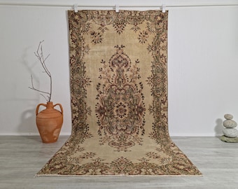 May include: A rectangular area rug featuring a beige background with a central medallion and intricate floral border patterns in shades of deep red, dark brown, and muted green. The rug displays a symmetrical design with ornate botanical motifs.