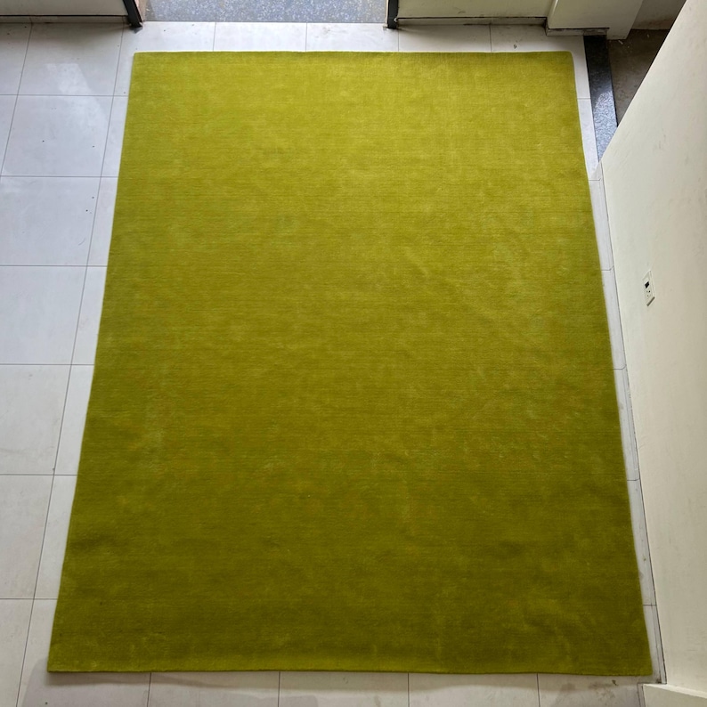 K&ouml;nnte beinhalten: Ein rechteckiger Teppich in einer kr&auml;ftigen, einfarbigen chartreuse-gr&uuml;nen Farbe. Der Teppich weist eine kurze, dichte Florstruktur mit einem gleichm&auml;&szlig;igen Erscheinungsbild &uuml;ber die gesamte Fl&auml;che auf, was f&uuml;r einen sauberen Look sorgt.