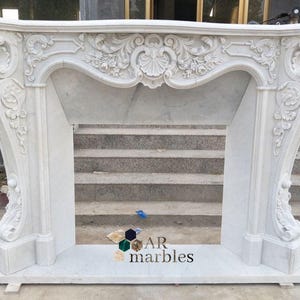 Puede incluir: Una taza de cerámica blanca con un asa negra y el texto "But First, Coffee" en negrita negra. La taza está sobre una superficie blanca. La taza mide aproximadamente 10 cm de alto.