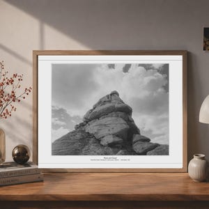 May include: A framed black and white landscape photograph featuring a large, jagged rock formation under a cloudy sky. The print includes the text "Rock and Cloud" and "Joshua Tree National Park, California - Joshua Aguiar, 2024" centered at the bottom.