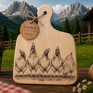 Könnte beinhalten: Helles Holzschneidebrett mit Griff, mit einer detaillierten Illustration von fünf Hühnern. Ein Anhänger mit Text hängt am Griff. Das Brett steht auf einem Holztisch mit einem Brotlaib und Blumen.