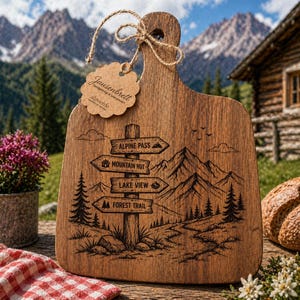 Peut inclure: Planche à découper en bois avec une scène de montagne et des panneaux directionnels gravés. Les panneaux indiquent « Alpine Pass », « Mountain Hut », « Lake View » et « Forest Trail ». La planche a un grain de bois naturel et une étiquette « Jausenbrett ».