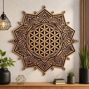 Könnte beinhalten: Ein großes, aufwendig geschnitztes Wandkunstwerk aus Holz. Das Design zeigt ein zentrales kreisförmiges Muster mit einem Blumen des Lebens-Motiv, umgeben von geschichteten geometrischen Formen und spitzen Kanten. Das Holz hat eine natürliche, hellbraune Farbe mit schwarzen Akzenten.