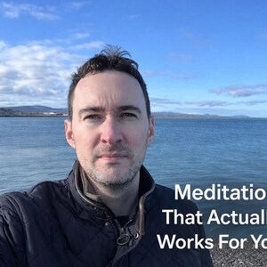 May include: A man in a dark jacket stands in front of a body of water under a blue sky with clouds. The text "Meditation That Actually Works For You" is visible in the lower right corner.
