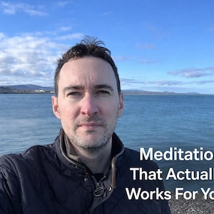 May include: A man in a dark jacket stands in front of a body of water under a blue sky with clouds. The text "Meditation That Actually Works For You" is visible in the lower right corner.