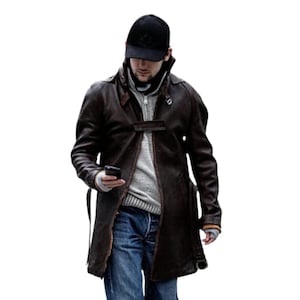 May include: A brown leather trench coat with a black baseball cap and blue jeans. The coat has a button closure and a belt. The person is holding a smartphone.